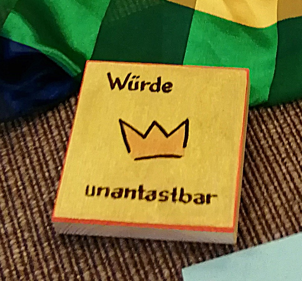 Eine hölzerne Tafel mit der Aufschrift 'Würde unantastbar'
