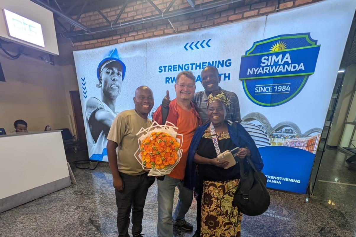 Willkommen in Ruanda mit orangem Blumenstrauß